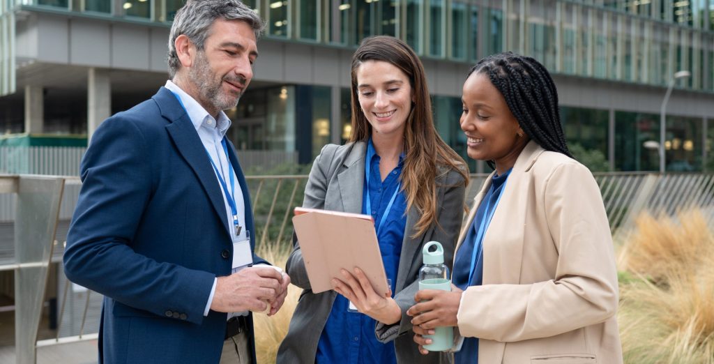 Diverse businesspeople having outdoor meeting using tablet fringe benefits