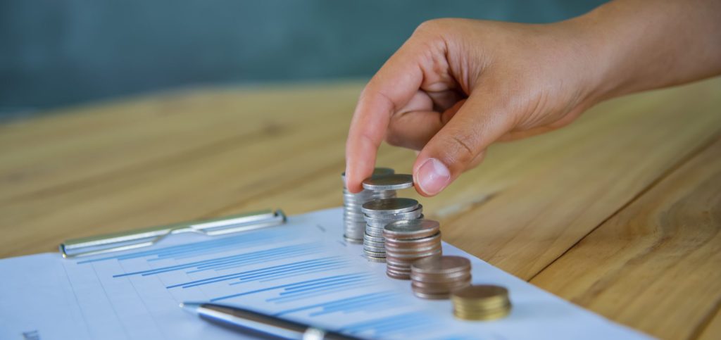 Close Up Hand Putting Money Coins Stack In Saving Money And Growing Business Concept exempt benefits