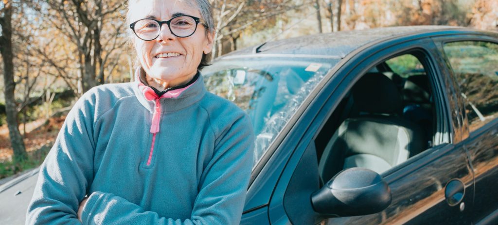 Older woman standing beside her car outdoors representing use of a novated lease calculator to estimate vehicle costs in Australia