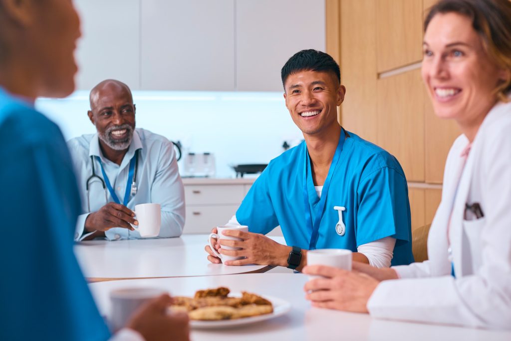 Medical Team Taking Coffee Break In Modern Hospital Kitchen