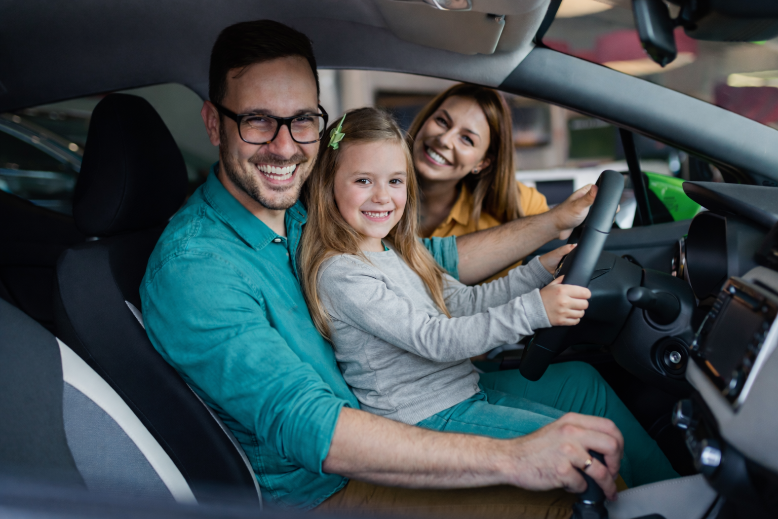 Family sitting inside a new car